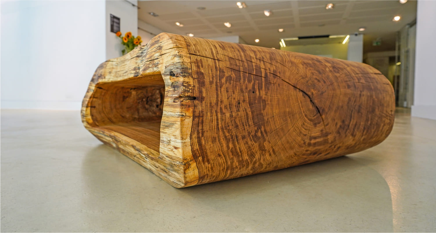 Close-up of OZE solid wood coffee table showing detailed wood grain, cracks, and natural edge