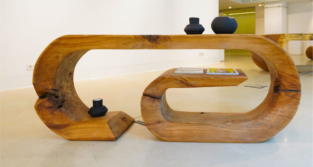 Side view of sculptural wooden OZE commode with integrated shelf in white gallery interior