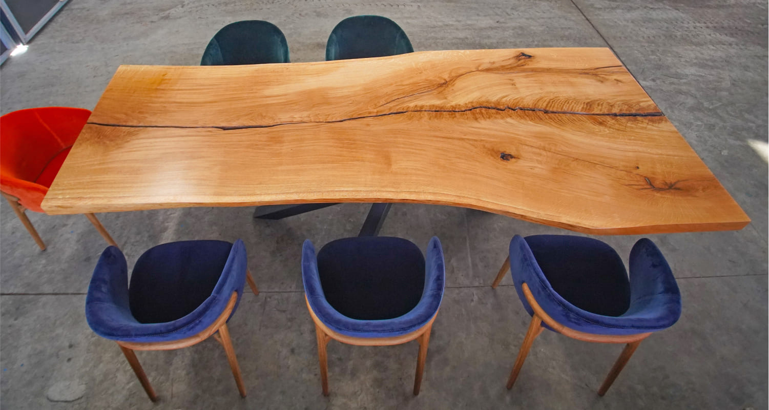 Top view of Sorrel solid wood dining table with natural cracks and velvet chairs