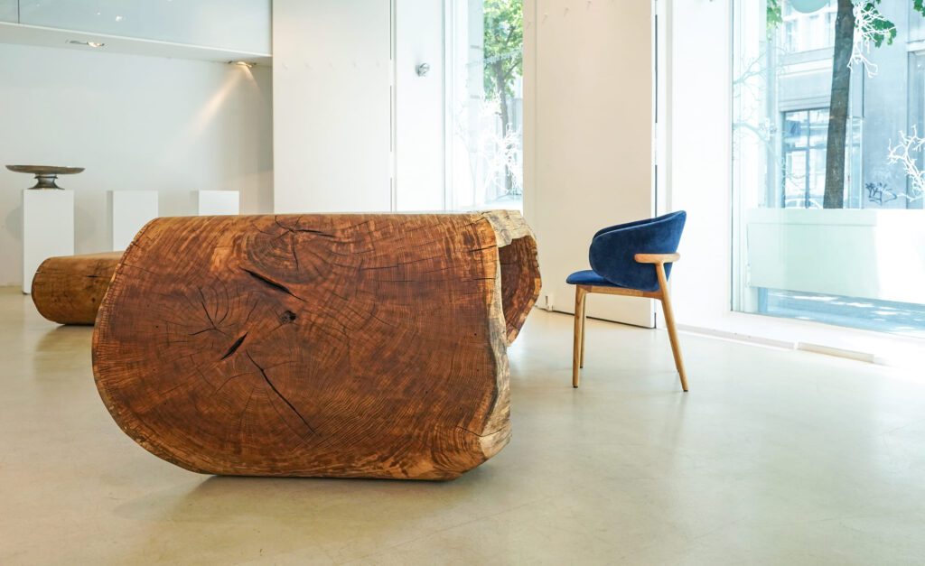 End grain of OZE sculptural coffee table with vintage chair in white gallery
